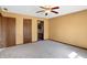 Well-lit bedroom featuring neutral carpet, multiple doors and a ceiling fan at 12 Danridge Dr, Danville, IN 46122