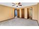 Spacious bedroom with neutral carpet, multiple doors leading to other rooms, and ceiling fan at 12 Danridge Dr, Danville, IN 46122