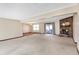 Open-concept living room with neutral carpet, a brick fireplace, and access to a sunroom at 12 Danridge Dr, Danville, IN 46122