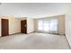 Bright living room with neutral walls and carpet, featuring a front door and large window at 12 Danridge Dr, Danville, IN 46122