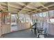 Enclosed porch with multiple windows, bead board lower walls and chairs, providing a space for relaxation at 12 Danridge Dr, Danville, IN 46122