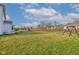 Spacious backyard with a swing set, firepit, green grass, and landscaping at 12073 Springtide Ln, Fishers, IN 46037