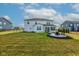 Large backyard with green grass, a firepit, and views of neighboring homes at 12073 Springtide Ln, Fishers, IN 46037