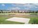 Community basketball court surrounded by green space, sidewalks, and neighboring houses under a blue sky at 12073 Springtide Ln, Fishers, IN 46037