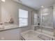 Modern bathroom with large glass shower, window, gray vanity, and neutral tiling at 12073 Springtide Ln, Fishers, IN 46037