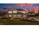 Two-story home with a brick facade, manicured lawn, and a colorful sunset at 12073 Springtide Ln, Fishers, IN 46037