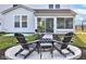 Cozy backyard firepit area with chairs, a small table, and an enclosed porch at 12073 Springtide Ln, Fishers, IN 46037