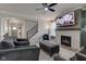 Cozy living room features a fireplace with mounted TV and comfortable seating area with ceiling fan at 12073 Springtide Ln, Fishers, IN 46037