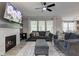 Bright living room with large windows, modern fireplace, and comfortable seating, plus a ceiling fan at 12073 Springtide Ln, Fishers, IN 46037