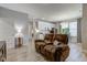 Bright, open-concept living room featuring a reclining sofa, and views of kitchen and dining area at 12073 Springtide Ln, Fishers, IN 46037