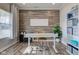 Well-lit office space with wood-look accent wall, modern desk, and ample storage on shelving unit at 12073 Springtide Ln, Fishers, IN 46037