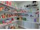 Walk-in pantry with extensive shelving for organized storage of food items and kitchen appliances at 12073 Springtide Ln, Fishers, IN 46037