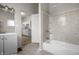 Bathroom with shower-tub combo, with view to the kitchen, neutral walls, updated flooring, and modern fixtures at 1211 W 30Th St, Indianapolis, IN 46208
