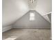 Cozy bedroom with a slanted roof, small window, and neutral carpet and walls at 1211 W 30Th St, Indianapolis, IN 46208