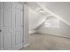 Slanted attic bedroom with a window, neutral walls and carpets, and a white door at 1211 W 30Th St, Indianapolis, IN 46208