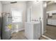 Functional laundry area with modern washing machine, water heater and window at 1211 W 30Th St, Indianapolis, IN 46208