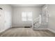 Open living room with staircase, vinyl flooring, and natural light from a window at 1211 W 30Th St, Indianapolis, IN 46208
