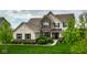 Beautiful two-story home with brick and siding exterior, professional landscaping, and lush green lawn at 12127 Whisper Ridge Dr, Noblesville, IN 46060