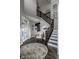 Inviting foyer with dark wood floors, staircase, area rug, and French doors to another room at 12127 Whisper Ridge Dr, Noblesville, IN 46060