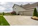 Three-car garage with an extra wide driveway and a well manicured lawn at 12127 Whisper Ridge Dr, Noblesville, IN 46060