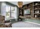 Stylish living room featuring a window, built-in wood shelving, and comfortable seating area at 12127 Whisper Ridge Dr, Noblesville, IN 46060