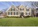 Charming two-story home with a manicured lawn, stone accents, and black shutters on a sunny day at 12433 Harvest Glen Blvd, Fishers, IN 46037