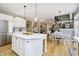 Bright eat-in kitchen features an island with a white countertop, wooden floors, and modern lighting at 12433 Harvest Glen Blvd, Fishers, IN 46037