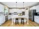 Modern kitchen with white cabinets, stainless steel appliances, and a central island with bar stools at 12433 Harvest Glen Blvd, Fishers, IN 46037