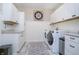 Well-organized laundry room with white cabinets, granite countertops, and modern appliances at 12433 Harvest Glen Blvd, Fishers, IN 46037