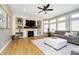 Cozy living room with built-in shelves and a fireplace, a ceiling fan, and large windows at 12433 Harvest Glen Blvd, Fishers, IN 46037
