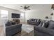 Comfortable living room with cozy seating, wood floors, ceiling fan and natural light from multiple windows at 1399 Hat Band St, Danville, IN 46122