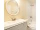 Bathroom features a white vanity, a round mirror, and a shower with a white tile surround at 14 N Edmondson Ave, Indianapolis, IN 46219