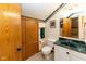 Bathroom featuring wood cabinets, a sink with green countertop, and a matching framed mirror at 154 Dover N Blvd, Brownsburg, IN 46112