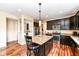 Modern kitchen featuring dark cabinets, a stainless steel fridge, granite countertops, and central island seating at 16753 Workington Way, Westfield, IN 46074