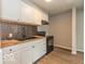 Bright kitchen featuring white cabinets, butcher block countertops, and modern black appliances at 1707 N Leland Ave, Indianapolis, IN 46218
