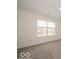 This bedroom features neutral walls and carpet and a window with a view of the neighborhood at 2290 Oakmont Dr, Plainfield, IN 46168