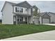 Attractive two-story home featuring a welcoming front porch, a spacious lawn, and a two-car garage at 2290 Oakmont Dr, Plainfield, IN 46168