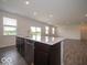 Kitchen island with stainless steel dishwasher, sink and view of open floor plan and outdoor scenery at 2290 Oakmont Dr, Plainfield, IN 46168