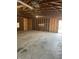 Interior of empty garage with open wood beams, unfinished walls, concrete floor and fluorescent lights at 2315 Caldwell Pl, Columbus, IN 47201