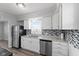 Kitchen featuring stainless steel appliances, white cabinets, and a large window at 2315 Caldwell Pl, Columbus, IN 47201