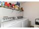 A functional laundry room includes a washer, dryer, and overhead shelving for storage at 2992 Sentiment Ln, Greenwood, IN 46143