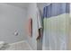 Bathroom showcasing the tiled shower with curtain and minimalist towel racks at 3655 Yellow Poplar Ct, Indianapolis, IN 46222