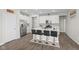 Modern kitchen boasts white cabinets, stainless steel appliances, and a large island with bar stool seating at 3719 Lexham Ct, Danville, IN 46122
