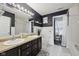 Well-lit bathroom with double sinks, black cabinets, and a walk-in shower at 3832 Kilburn Ct, Indianapolis, IN 46228