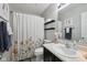 The bathroom has a shower and tub combination, floral shower curtain and floating shelving at 3832 Kilburn Ct, Indianapolis, IN 46228