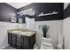 Modern bathroom featuring a double vanity, granite countertops, and a decorative shelf with plants at 3832 Kilburn Ct, Indianapolis, IN 46228