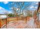 Expansive wooden back deck with decorative railings and a view of the yard with mature trees and landscaping at 5515 Shorewood Dr, Indianapolis, IN 46220