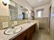 Bathroom with double sink vanity, mirror, shower, and tiled walls and flooring at 5850 Paradise Ln, Martinsville, IN 46151