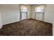 A bright, empty bedroom with wall-to-wall carpet offers two windows with curtains for natural light at 5850 Paradise Ln, Martinsville, IN 46151