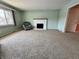 Cozy living room showcasing a white fireplace, plush carpet, and a large window for natural light at 5850 Paradise Ln, Martinsville, IN 46151